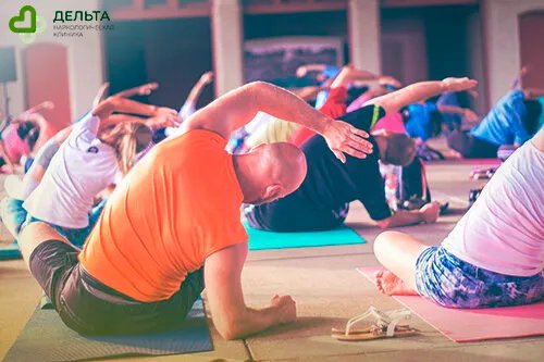 Люди занимаются йогой в спортзале